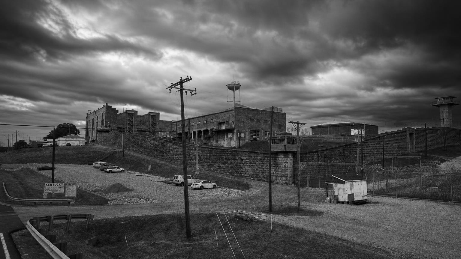 Monochrome editorial rendering of Kentucky State Penitentiary's walls and historic buildings.