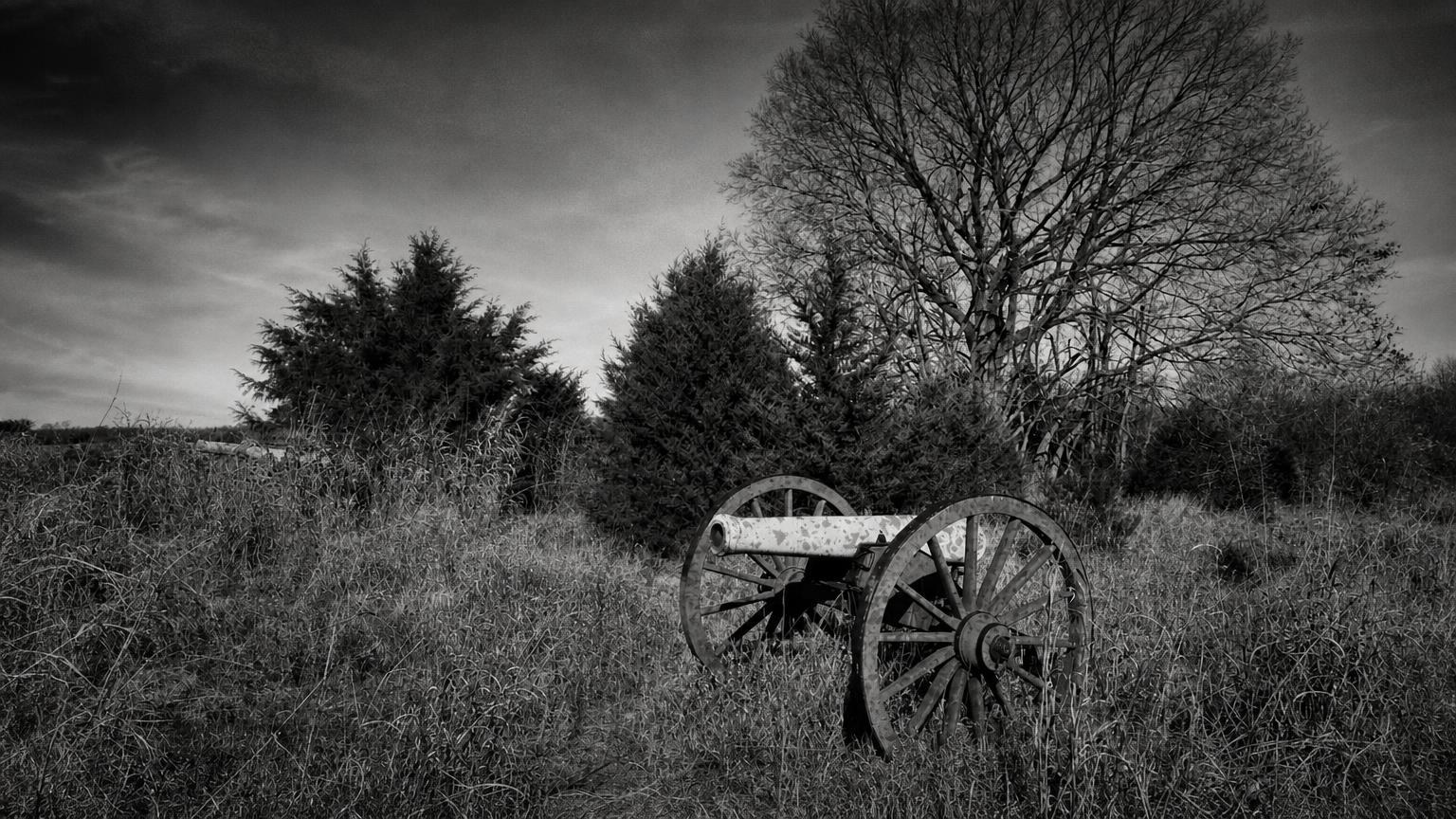 Monochrome editorial rendering of a cannon in a grassy Antietam battlefield landscape.