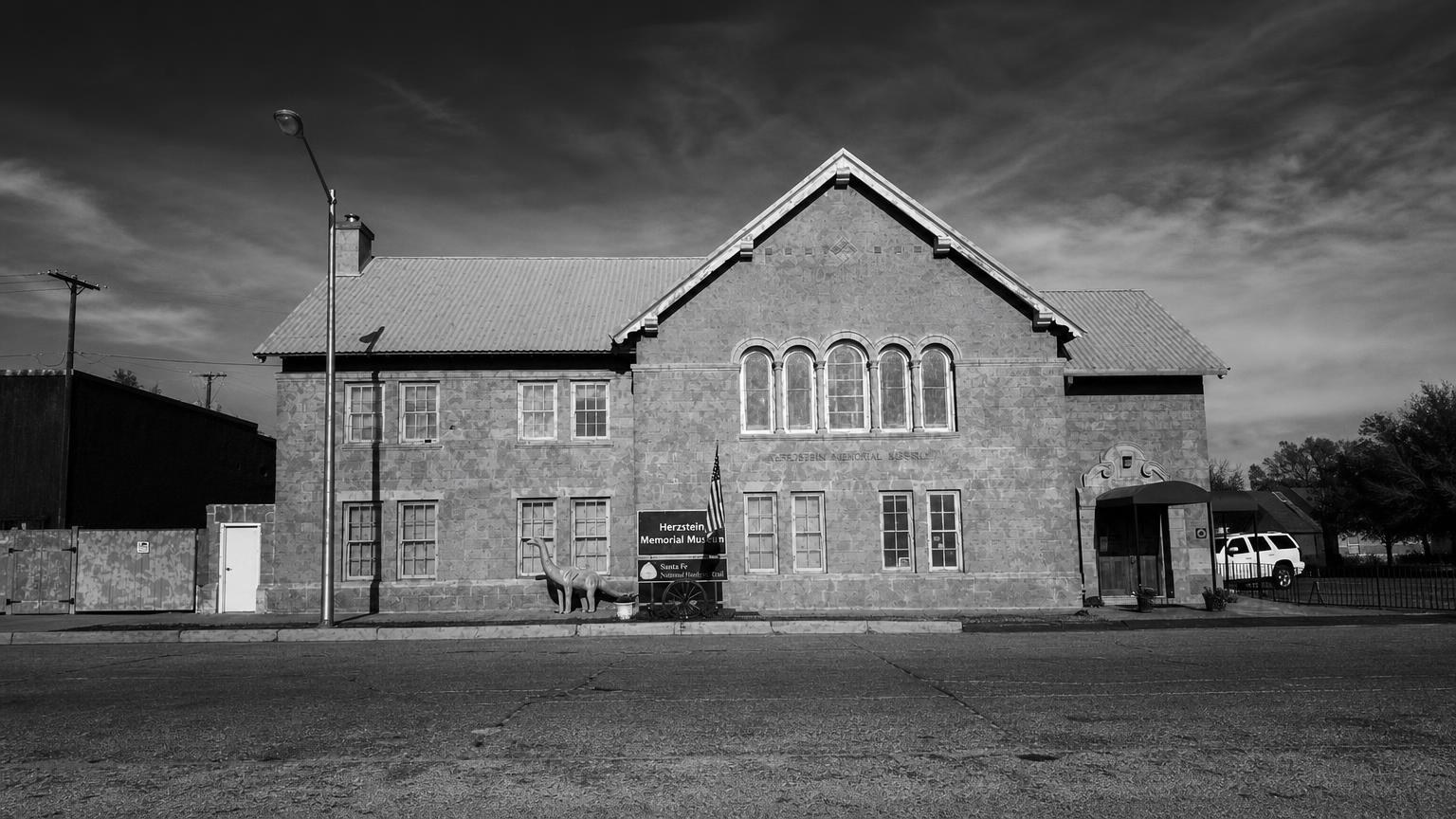 Monochrome editorial rendering of the Herzstein Memorial Museum's stone facade.