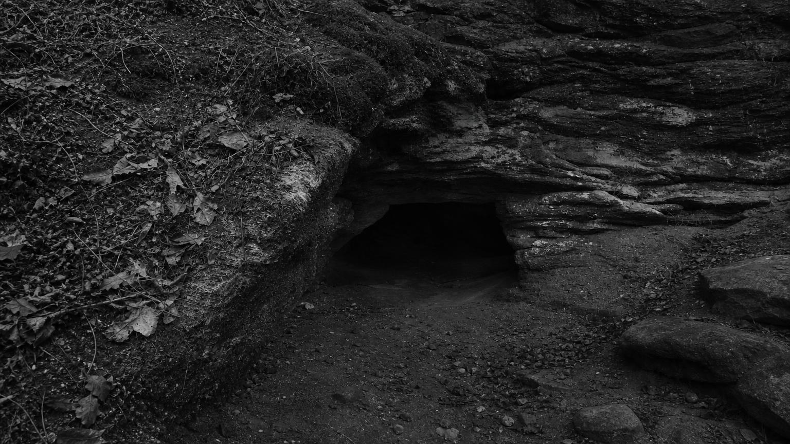 Monochrome editorial rendering of a low cave entrance beneath layered rock, based on the migrated Devil's Hole reference.
