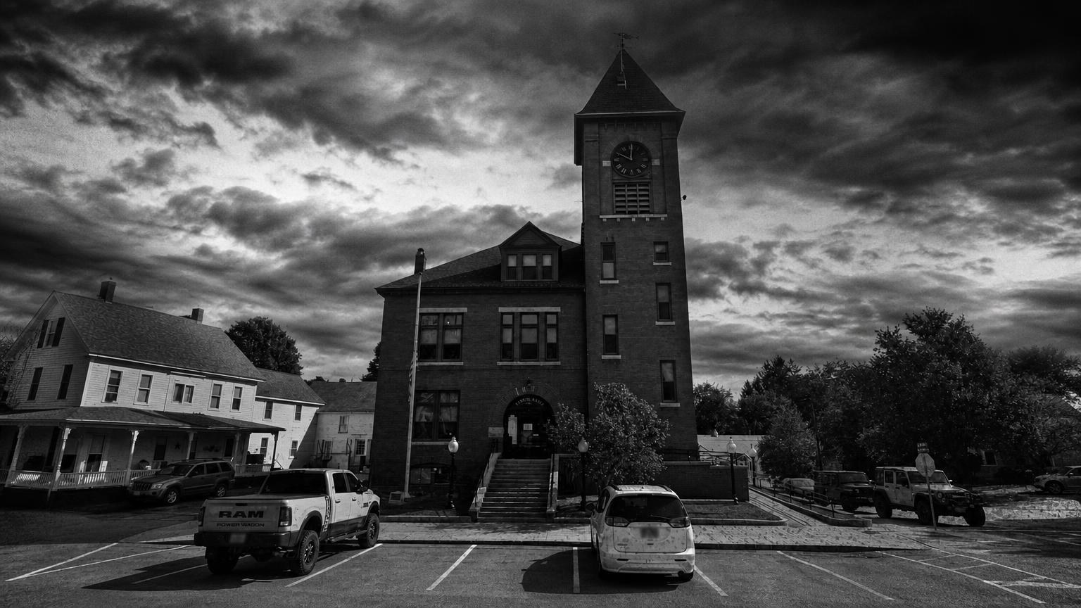 Monochrome editorial rendering of Alton Town Hall and its clock tower, with parked vehicles in front.