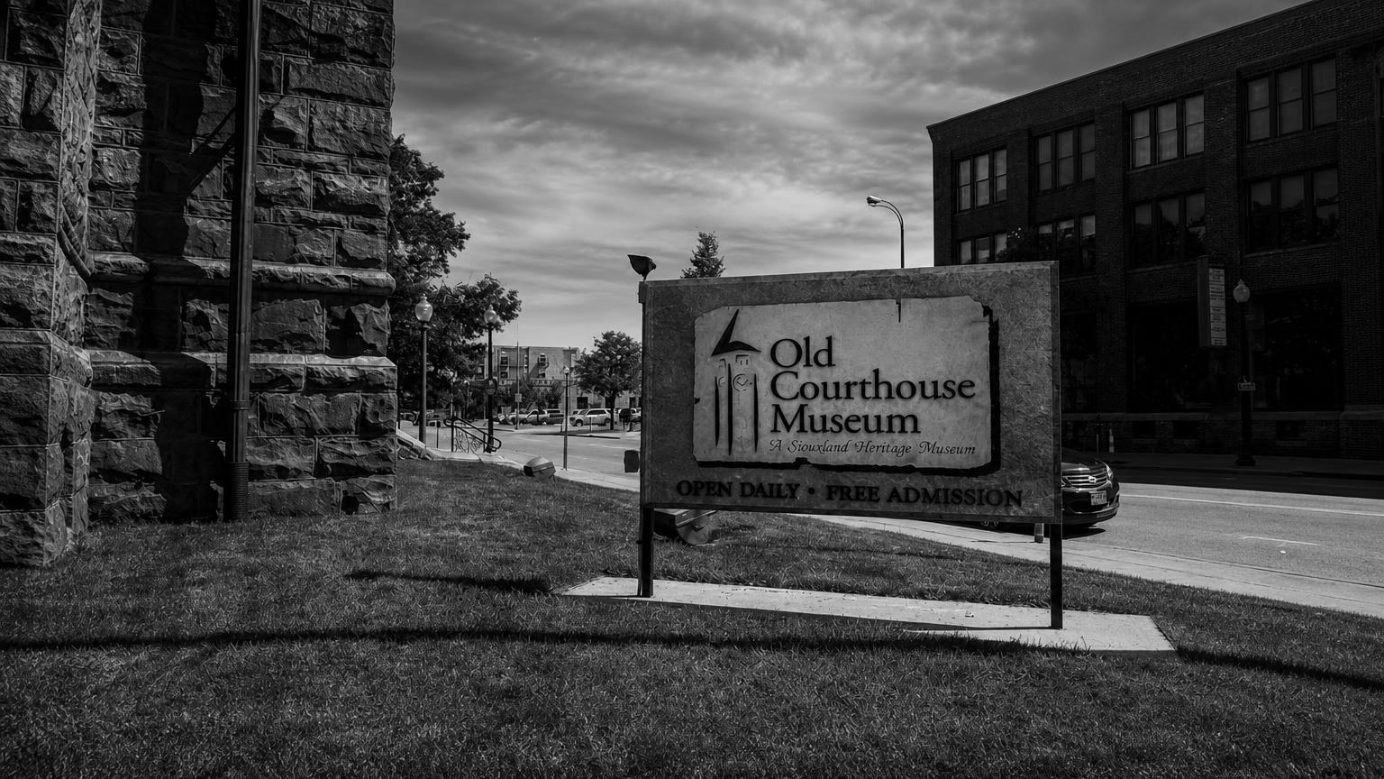 Monochrome editorial rendering of the Old Courthouse Museum sign and stone building.