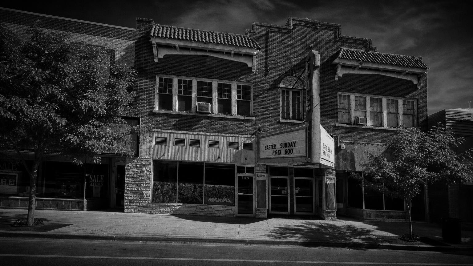 Monochrome editorial rendering of Acme Theatre's brick street frontage and projecting marquee in Riverton.