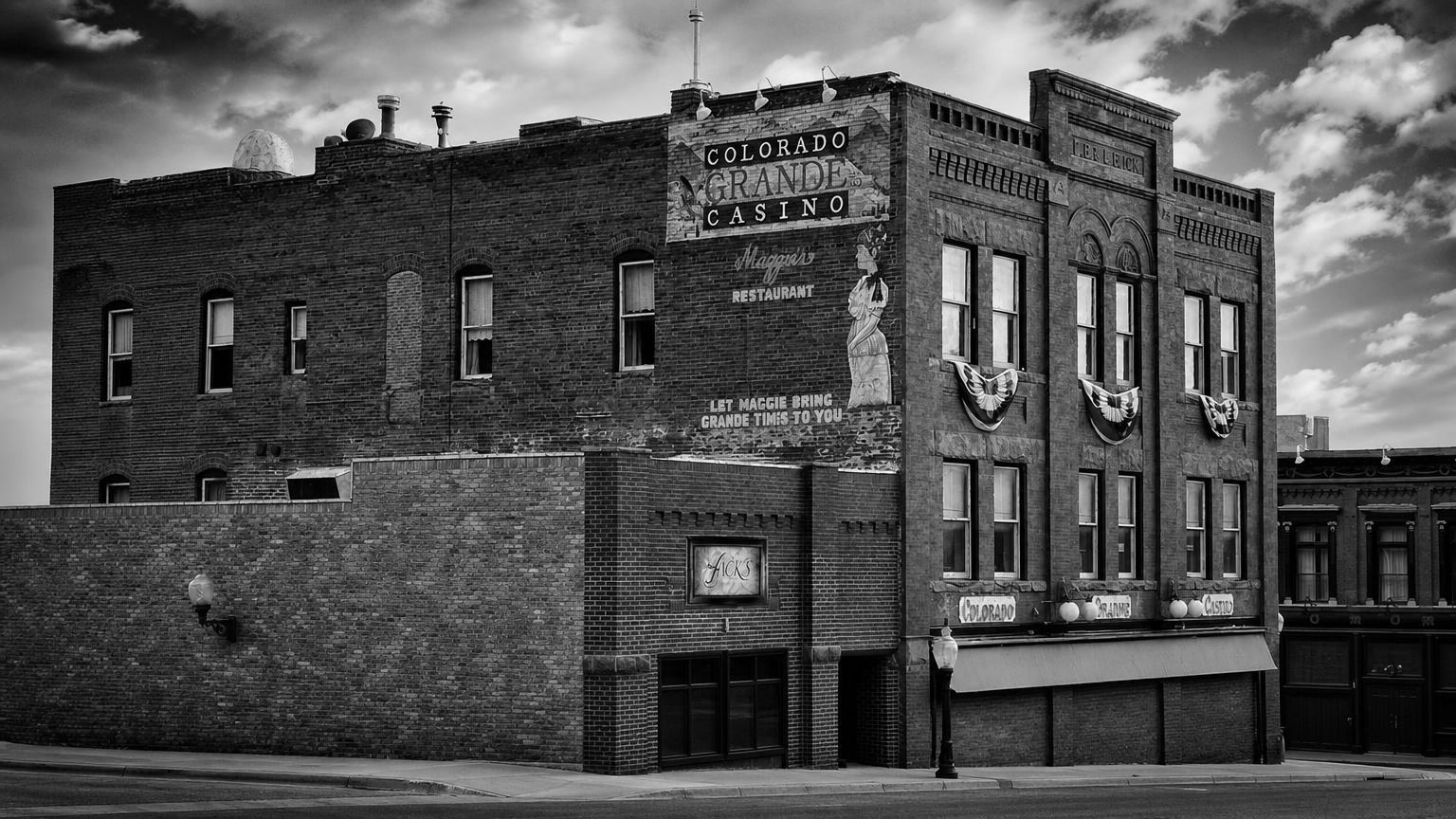 Monochrome editorial rendering of the Colorado Grande Casino's brick facade and historic signs.