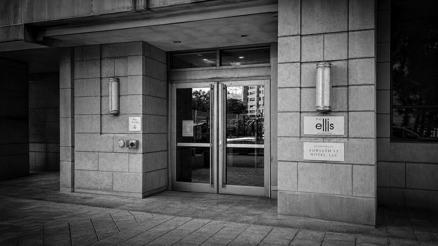 Monochrome editorial rendering of Ellis Hotel's stone entrance and glass doors in Atlanta.