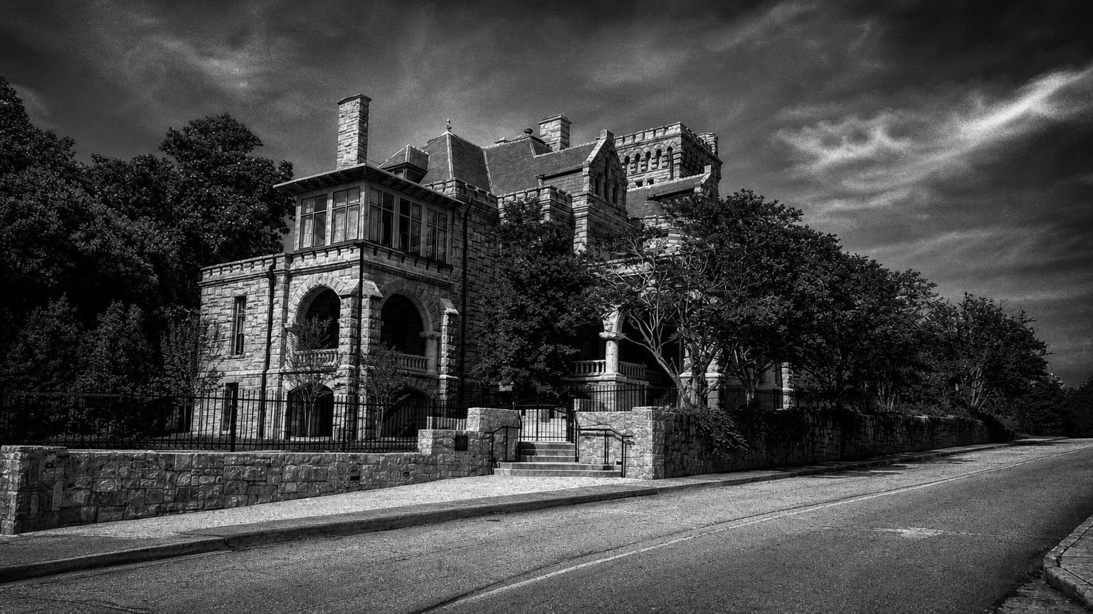 Monochrome editorial rendering of Rhodes Hall's stone facade, roofline and roadside wall in Atlanta.
