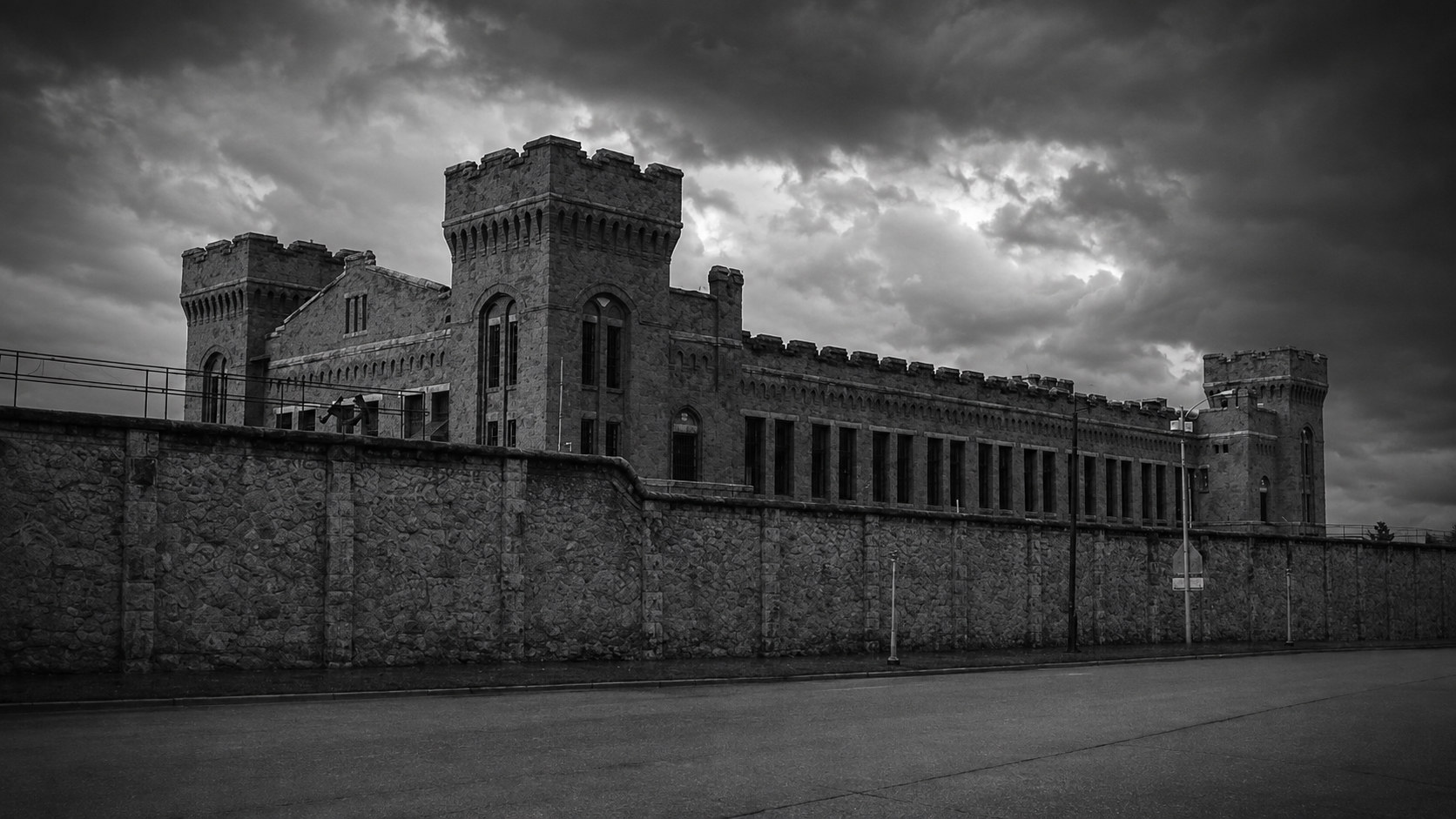 Monochrome editorial rendering of the Old Montana Prison exterior.