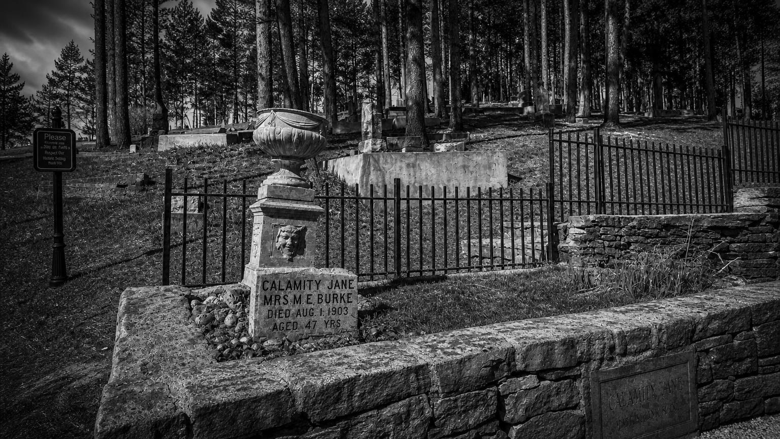 Monochrome editorial rendering of Mount Moriah Cemetery's Calamity Jane memorial.